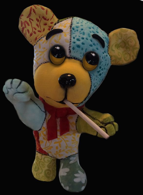 A colorful patchwork teddy bear with mismatched fabric patterns, large black eyes, and a red bow tie holds a white stick in its mouth while waving against a black background.