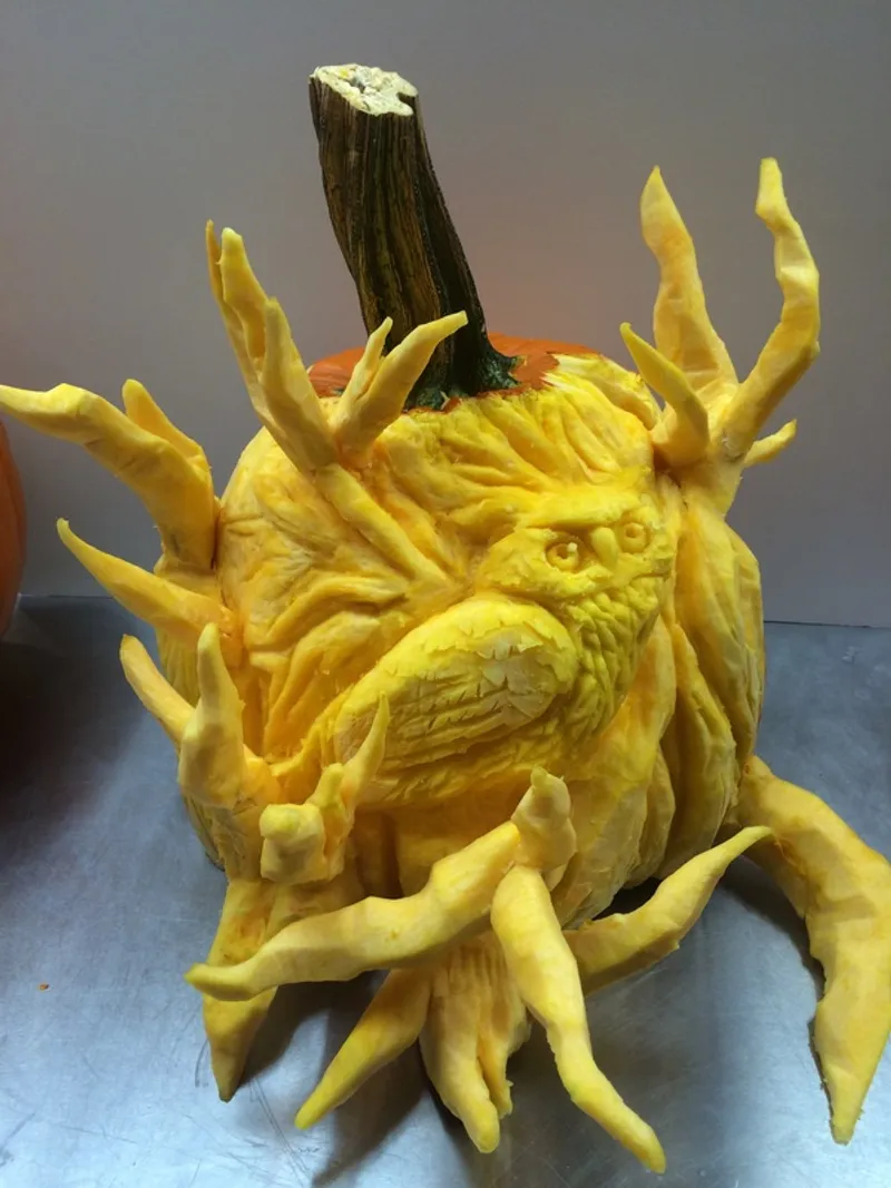 A yellow squash intricately carved into a monstrous creature with sharp, claw-like spikes protruding from its body and a detailed, textured face.