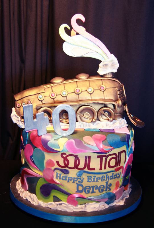A two-tiered birthday cake for Derek's 40th features a colorful, psychedelic "Soul Train" design on the bottom tier and a gold locomotive topper with a large silver "40" numeral.
