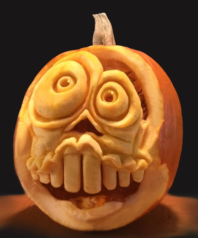 A carved vegetable features a grotesque, three-dimensional face with bulging eyes and a wide, toothy grin, set against a dark background.