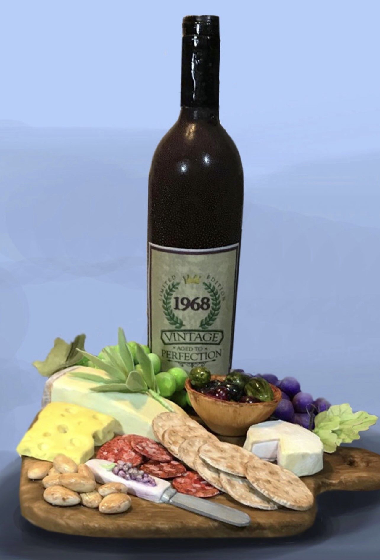 A hyper-realistic sculpted cake featuring a dark glass wine bottle labeled "1968 VINTAGE — Aged to Perfection" with a laurel wreath, alongside an artfully arranged charcuterie board on a rustic wooden platter with Swiss cheese, brie, salami, crackers, olives, grapes, and fresh herbs.