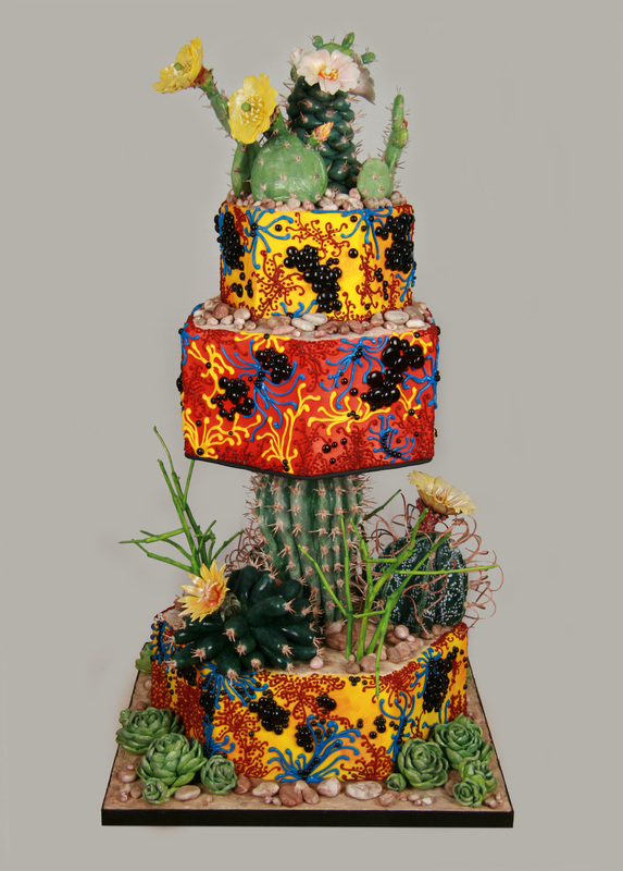 A three-tiered cake decorated with vibrant yellow and red patterns, black bead accents, and topped with realistic-looking cacti and succulents.