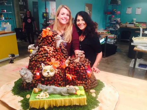 Kim Simons and a partner beside a squirrel-themed cake on Food Network's Duff Till Dawn.