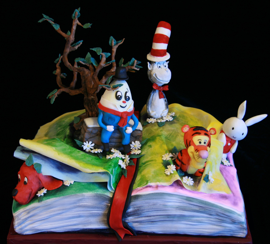 A whimsical cake shaped like an open book features fondant figures of Dr. Seuss characters, including the Cat in the Hat, Thing 1, a tiger, a rabbit, and a red dog, set against a black background.