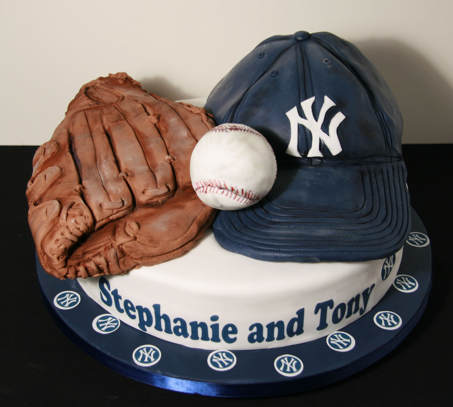 A baseball-themed cake featuring a detailed fondant baseball glove, a baseball, and a New York Yankees cap, with "Stephanie and Tony" written on the side.