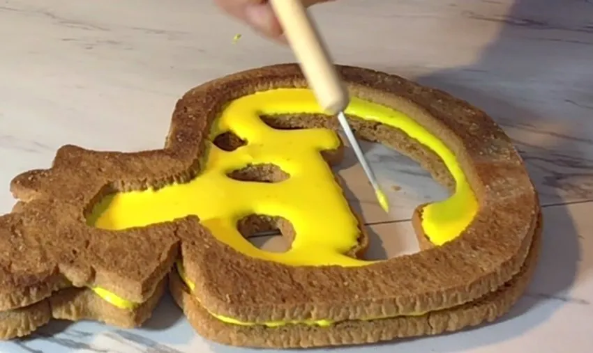A border of royal icing is added to the back cookie to create a chamber.