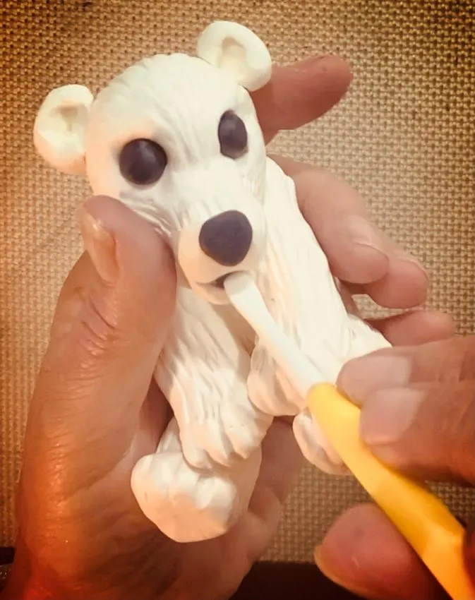Adding black eyes, nose, and mouth to the bear face.