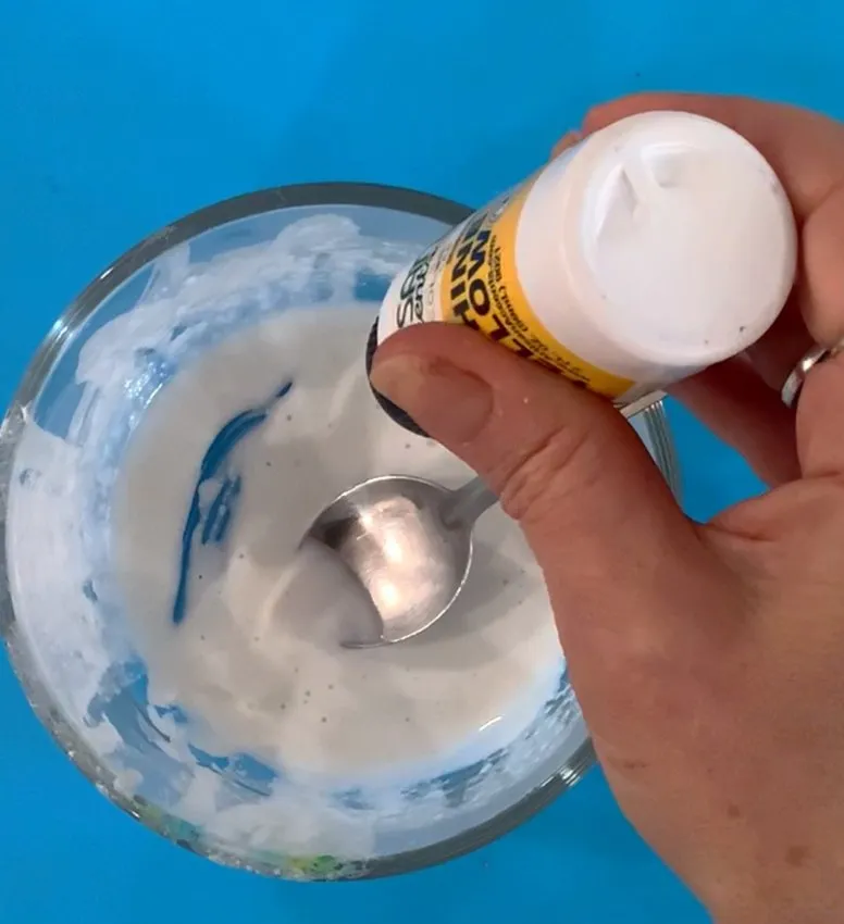 Squeezing edible gel color into the dissolved fabric mixture.