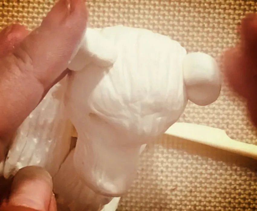 Attaching ears to the polar bear head with fur texture.