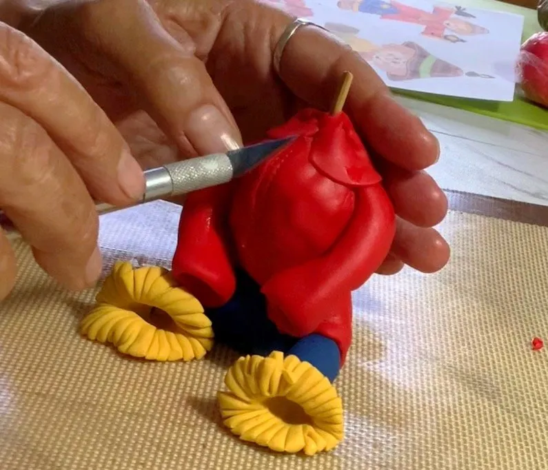 Adding the red fondant collar around the scarecrow's neck.