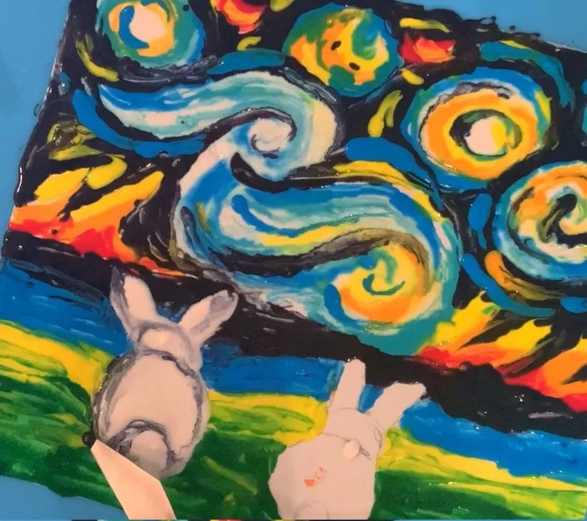 Finished edible paper art with two bunnies under a starry night sky.
