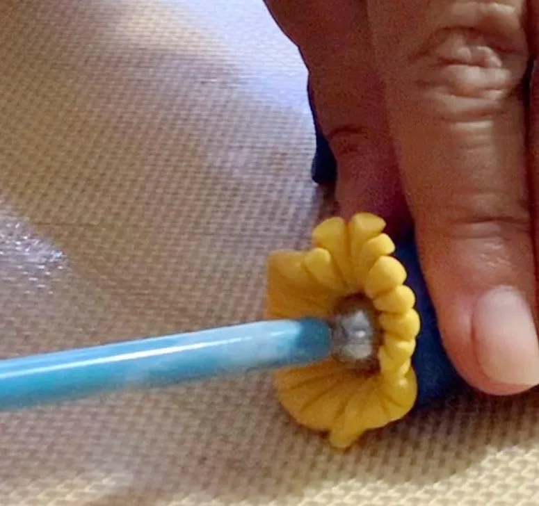 Adding yellow fondant straw to the bottom of the legs.
