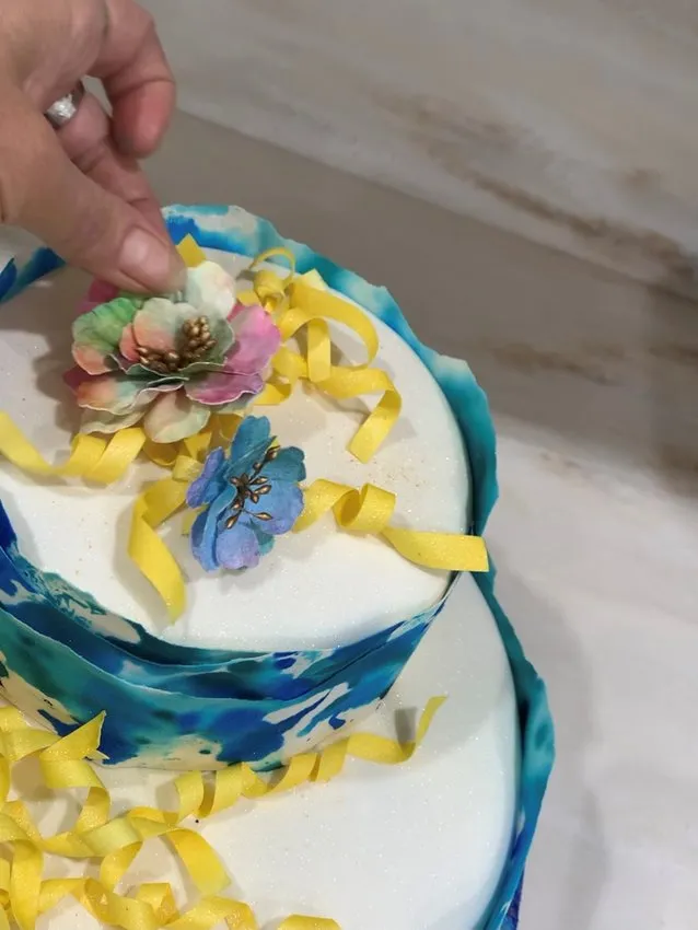 Placing wafer flower decorations on the cake.