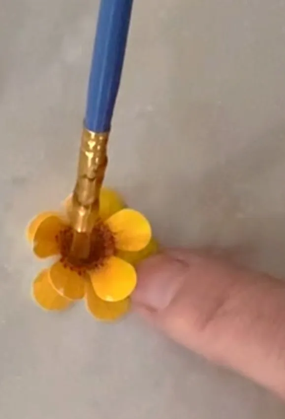 Hand assembling edible paper flowers with piping gel.