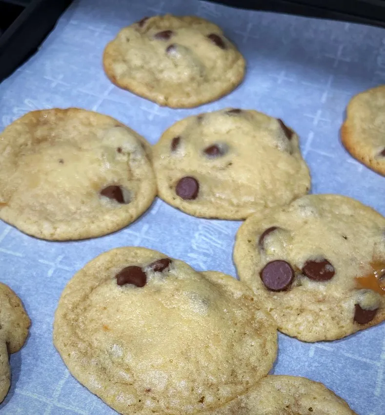 Baked golden-brown cookies on parchment paper