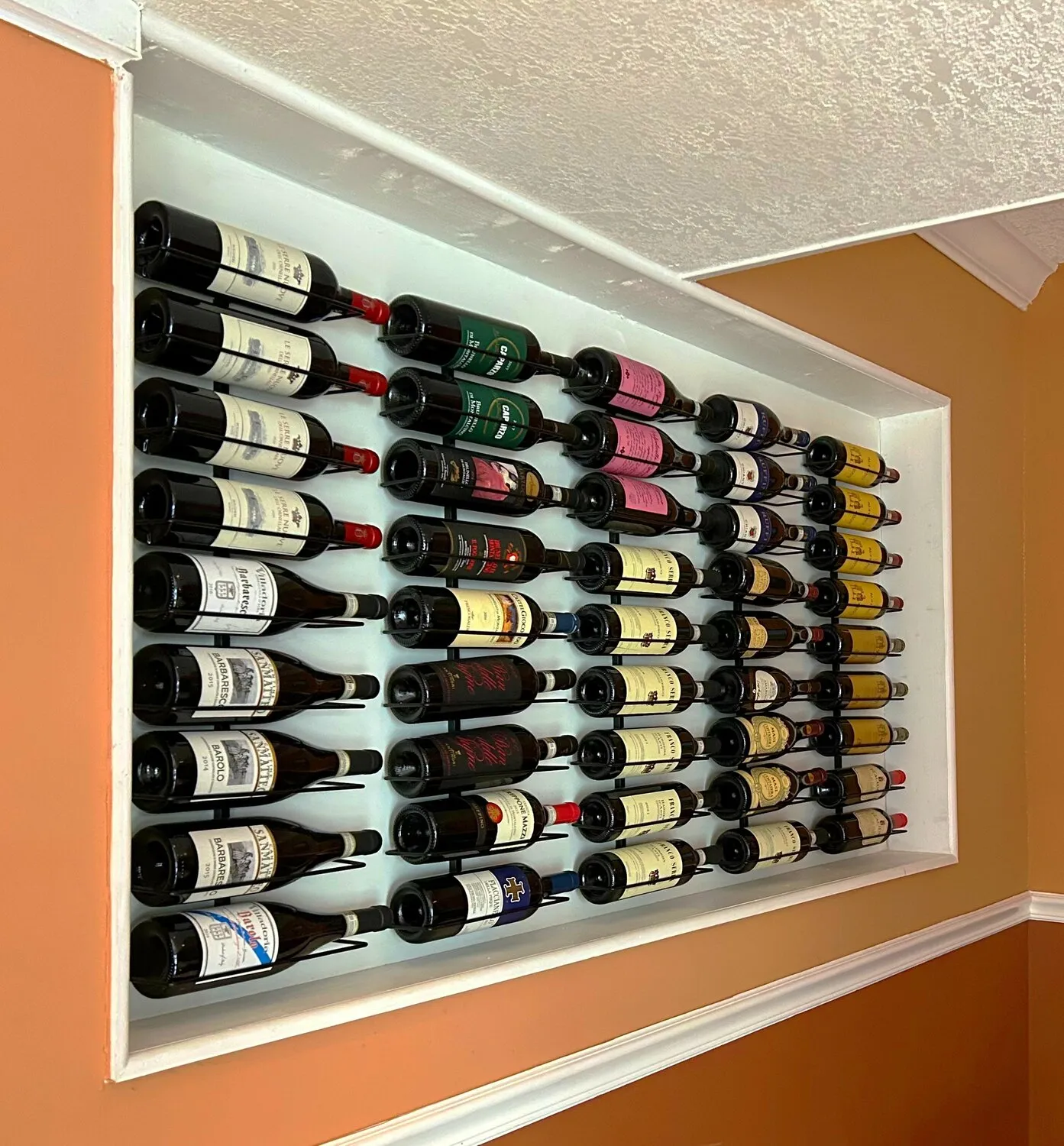 A wall-mounted wine rack displaying wine bottles at Solaia Restaurant in Monticello, New York.