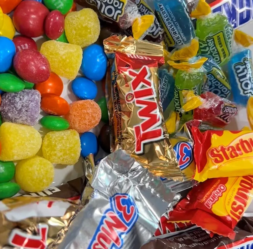 Assorted Halloween candies including chocolate bars, gummies, and lemon drops.