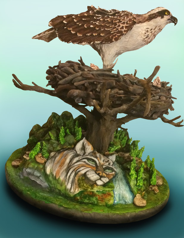 A sculpted cake diorama featuring an osprey perched atop a large stick nest in a tree, which rises from a rocky base where a striped wildcat rests beside a small waterfall.