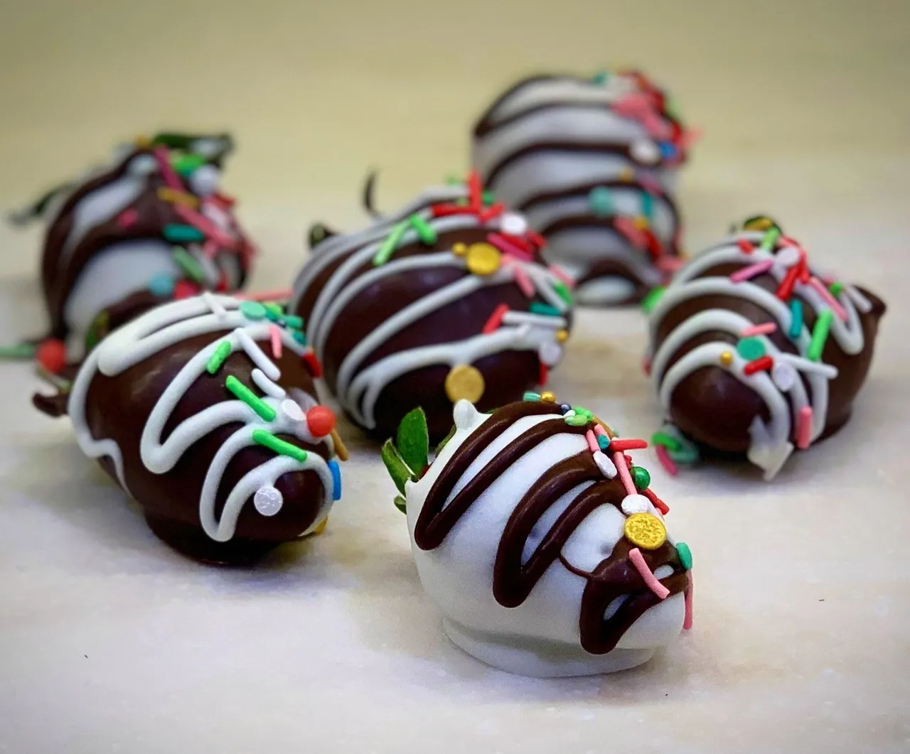 Chocolate-covered strawberries decorated with white and dark chocolate drizzle and sprinkles