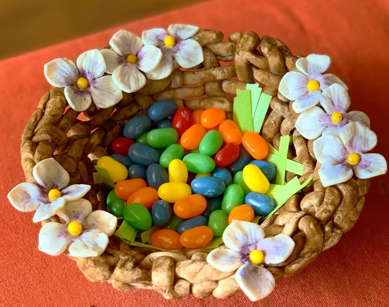 An edible chocolate Easter basket woven from chocolate, filled with colorful jelly beans and candy
