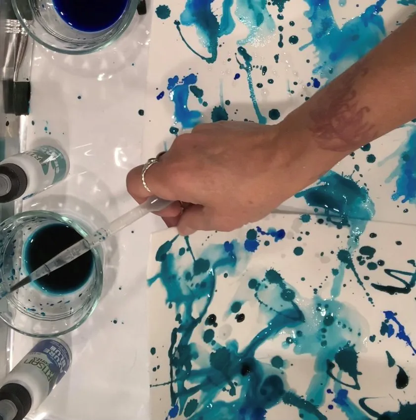 Dripping blue edible color onto edible paper.
