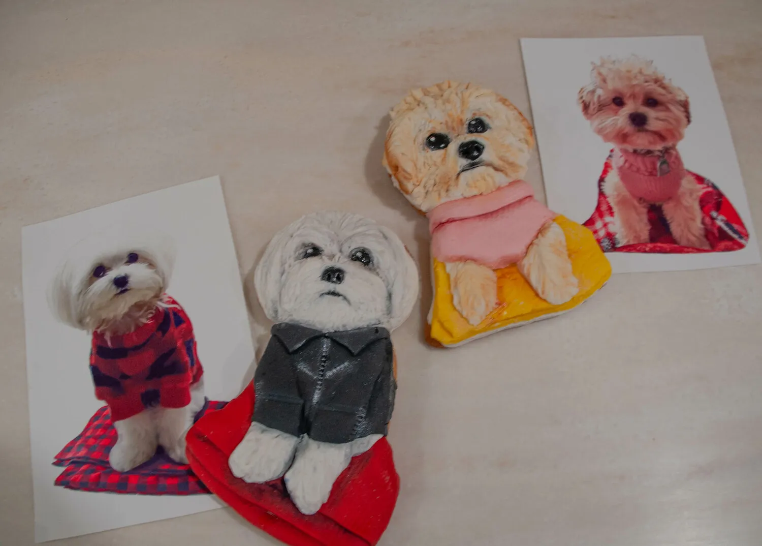 Two intricately decorated sugar cookies shaped and designed to look like small white dogs including a Maltese and a Havanese