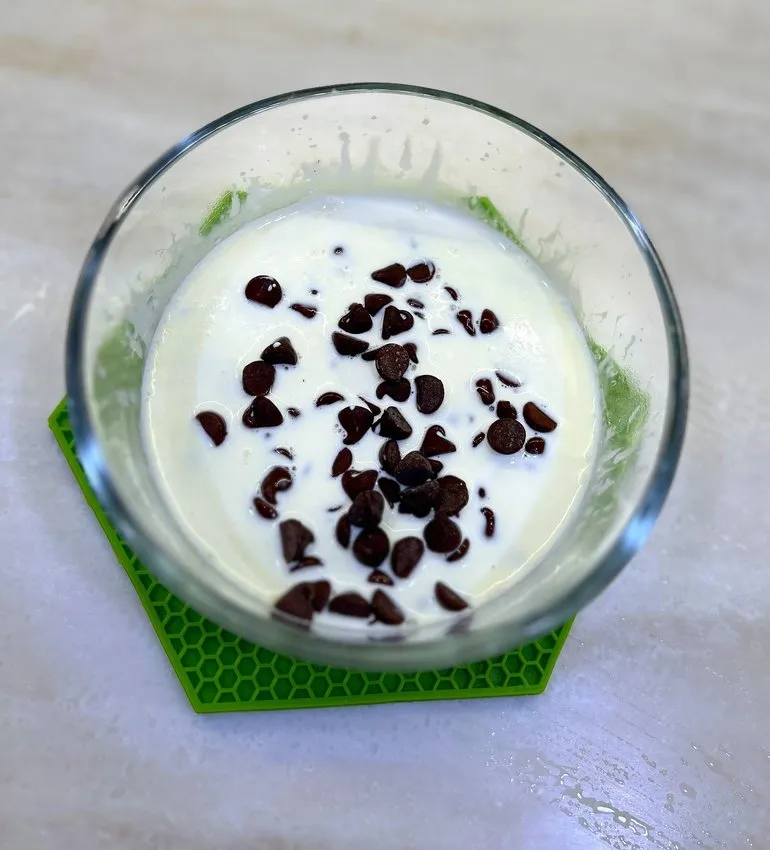 Glass bowl with cream and chocolate pieces added