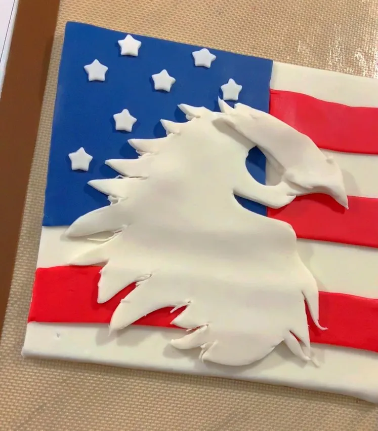 White fondant eagle head cutout centered on the flag cake.