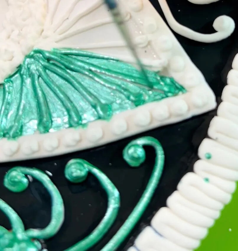 Decorating the hat with green icing and fondant details