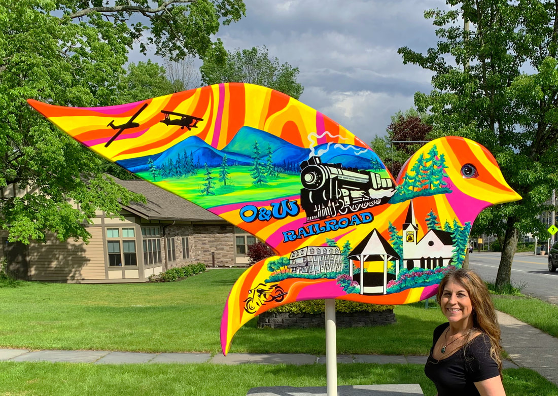 A brightly colored, psychedelic bird-shaped sign features peace symbols, flowers, and beer mugs, with text reading "Hector's Inn Original Woodstock Watering Hole" and "Welcome to the Haight Ashbury."