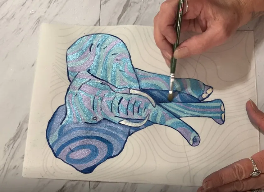 Dusting blue and purple shadows onto the elephant.