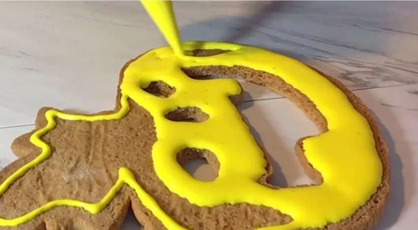 Yellow royal icing fills the back cookie piece to the edges.
