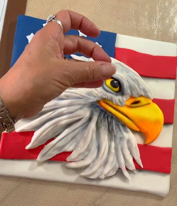 Final white fondant highlights and edible dust on the eagle head.