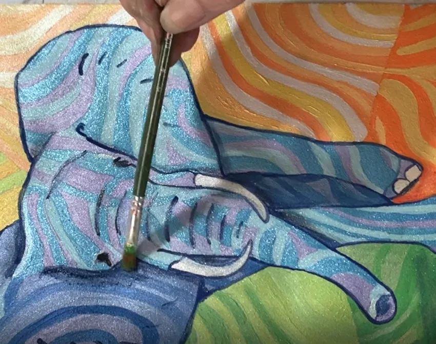 Applying final green details to the elephant painting.