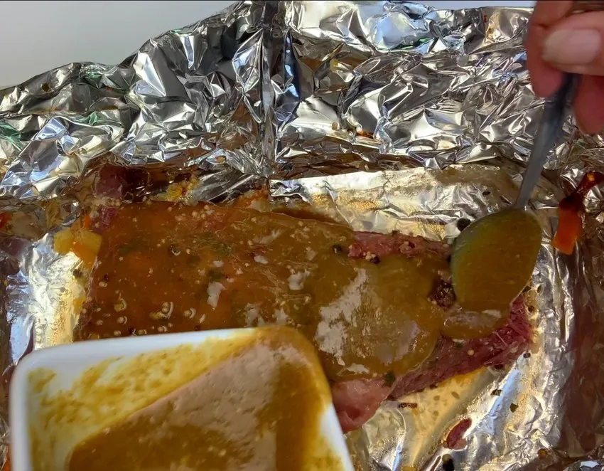 Pouring glaze over the cooked brisket