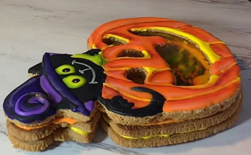 The top cookie is glued onto the bottom cookie with royal icing.