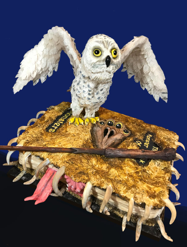A white snowy owl with spread wings perches atop a grotesque, furry monster book featuring a screaming face, sharp teeth, and a protruding tongue, with a wooden wand resting across its cover.