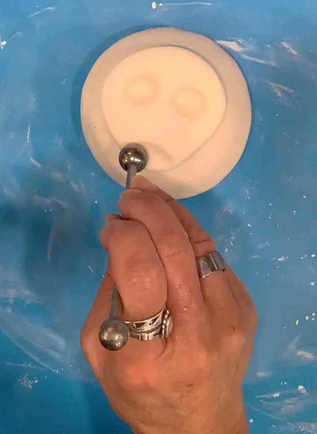 Using a ball tool to add face details to the fondant head.