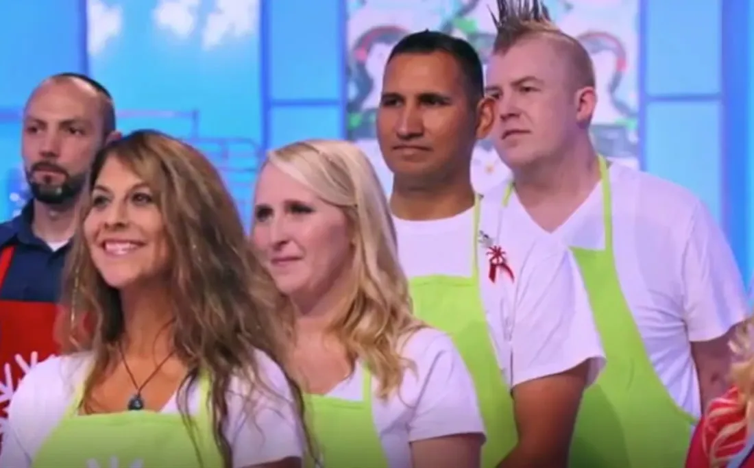 Five contestants in lime green aprons on the Holiday Wars set.