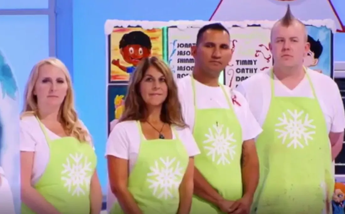Four contestants in lime green aprons in a row on the Holiday Wars set.
