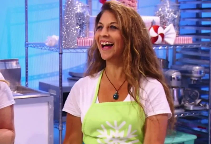 Kim Simons in a lime green apron in the Holiday Wars kitchen.