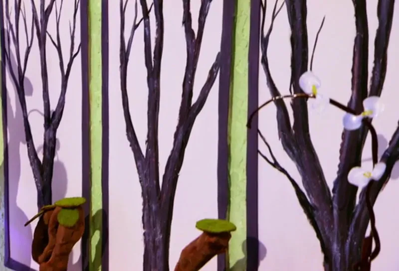 Decorative wall panel with tree branches and white flowers on the Holiday Wars set.