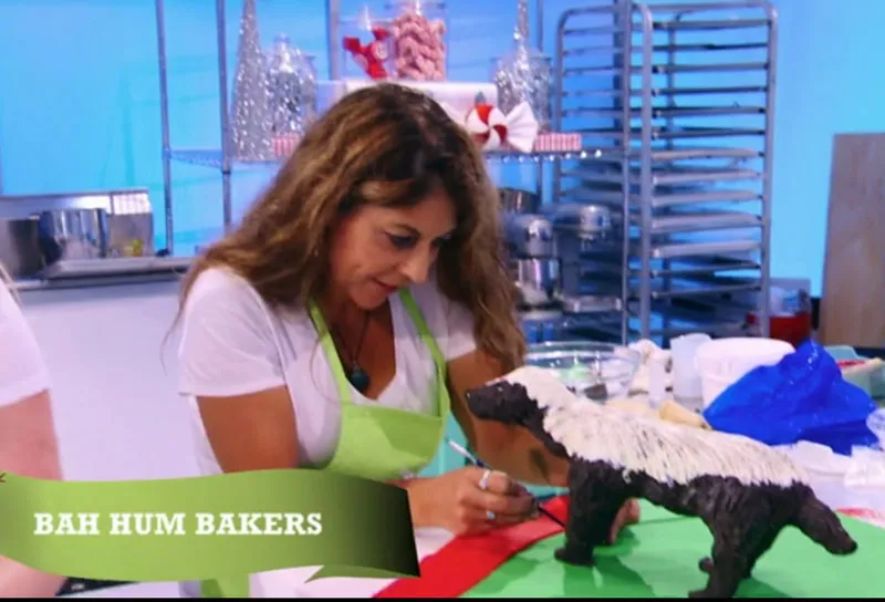 Kim Simons decorating a skunk-shaped cake on Holiday Wars.