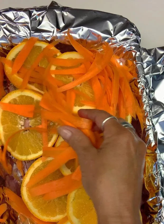 Shredded carrots layered over the orange slices
