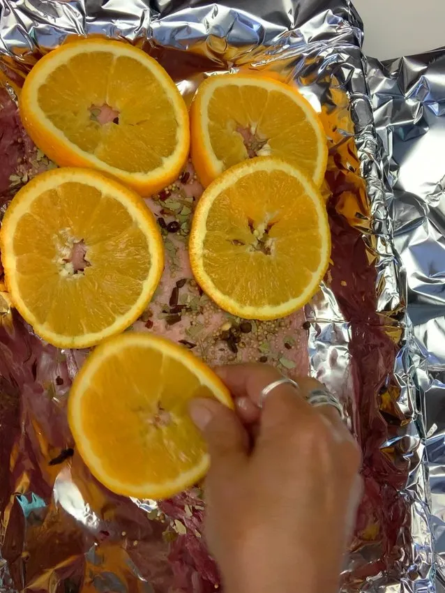 Orange slices placed on top of the seasoned brisket