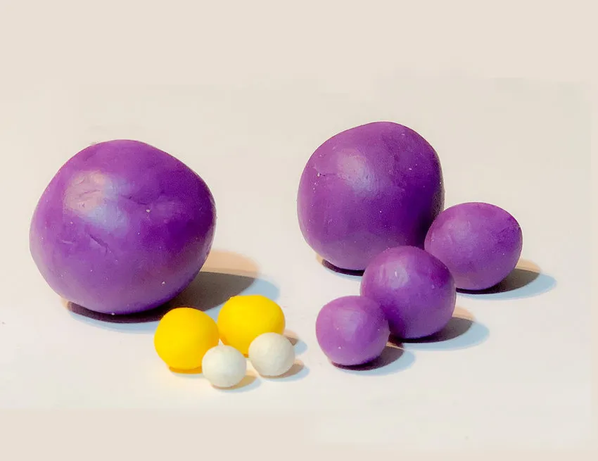 Ball of purple modeling chocolate for the lovebird body on a work surface.