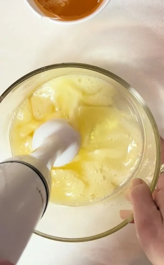 An immersion blender creates foam in the leftover gelatin mixture.