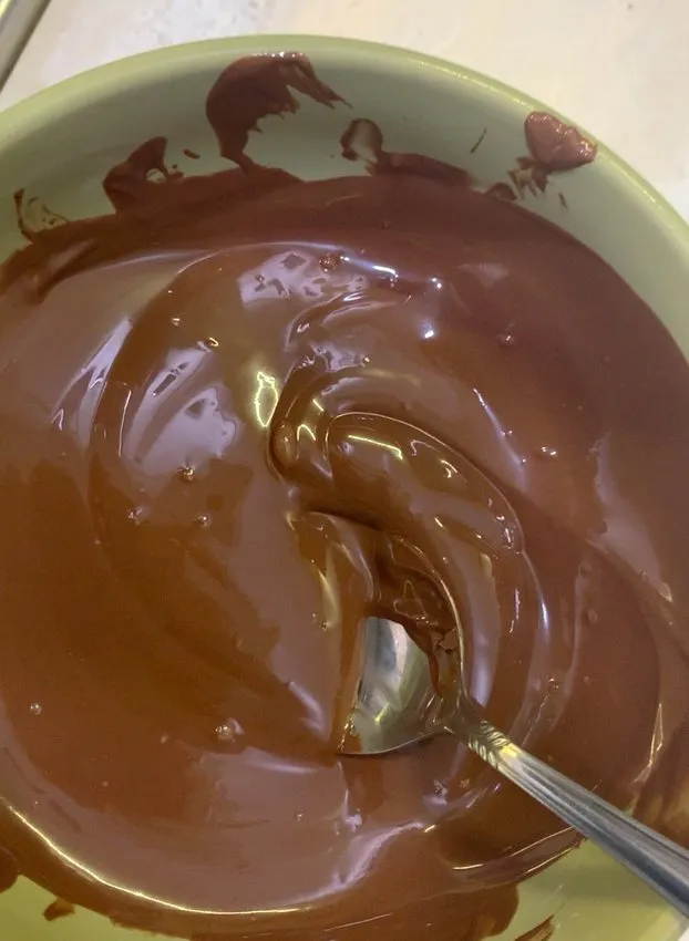 Bowl of melted chocolate with a spoon