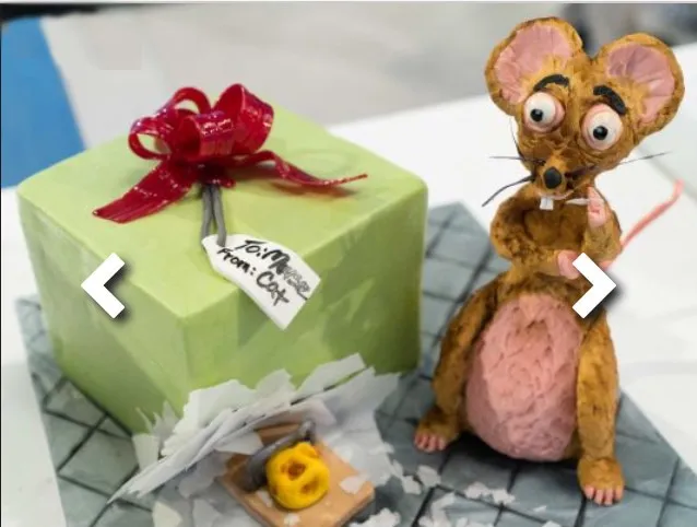 A Ratatouille-themed mouse cake next to a mousetrap prop.