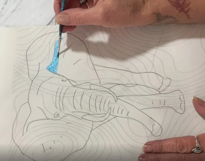 Painting blue edible color onto the elephant body.